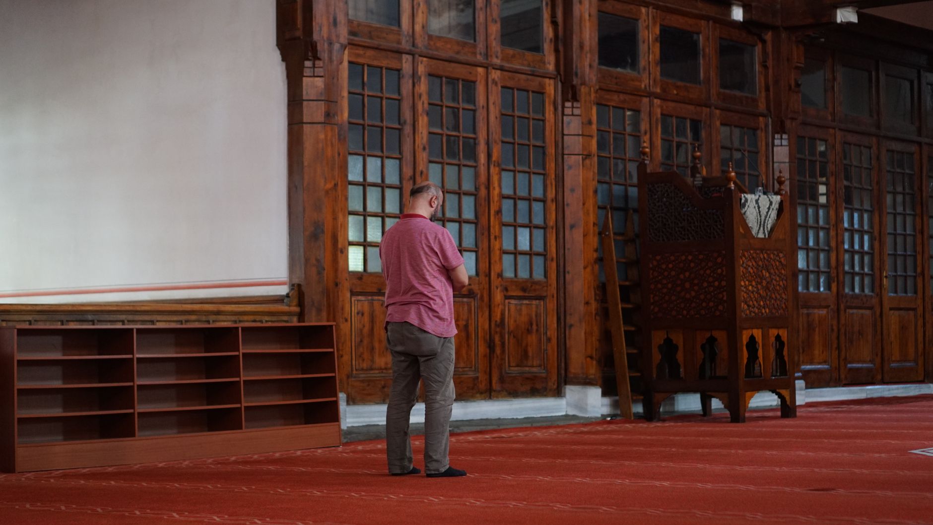 A student engaged in seeking knowledge in Islam within a quiet, traditional mosque interior setting.