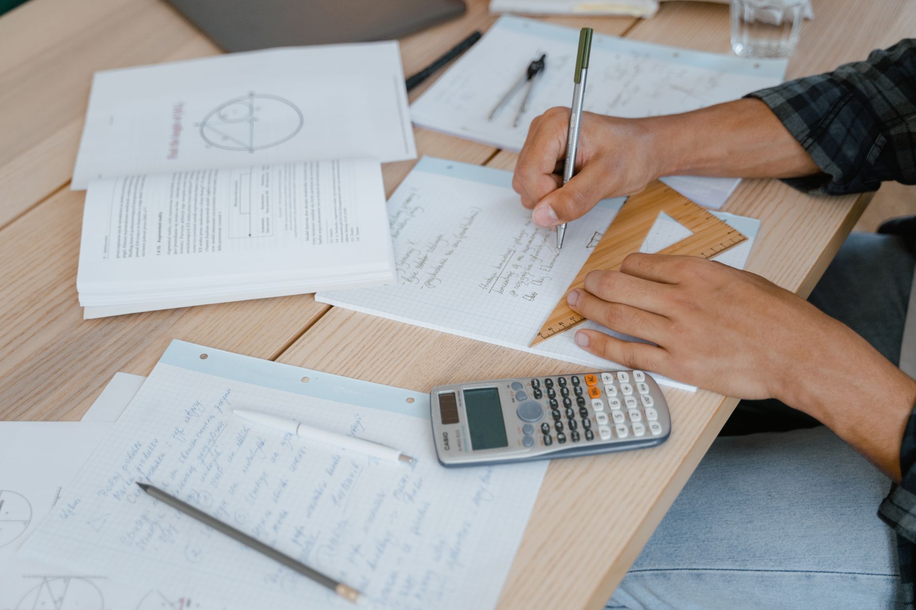 A calculator and notebook on a desk to calculate the Islamic rules of Zakat.