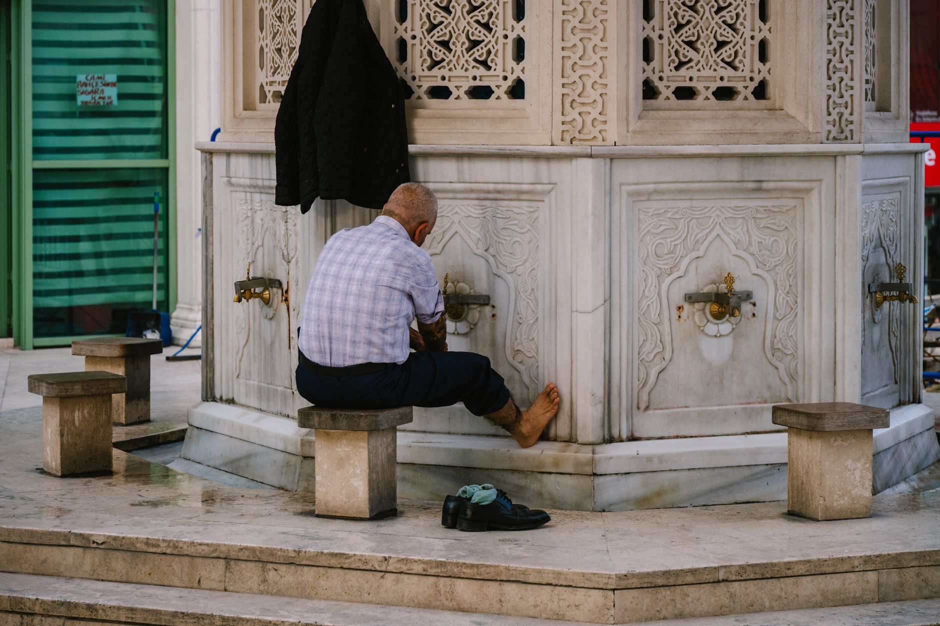 A Muslim man performing the wiping of the head as part of avoiding Wudu mistakes.