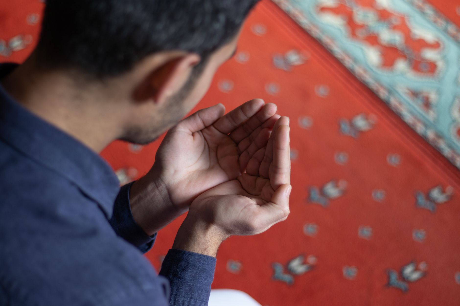 Hand holding prayer beads to count Salawat upon the Prophet Muhammad ﷺ during a quiet moment.
