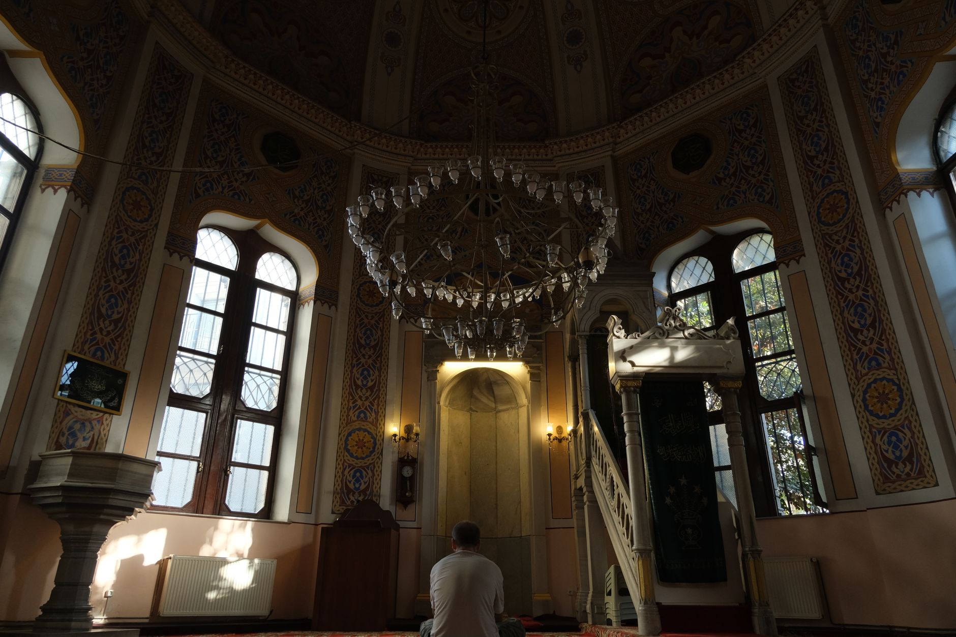 A person reading the Quran to understand the scales of deeds in Islam.