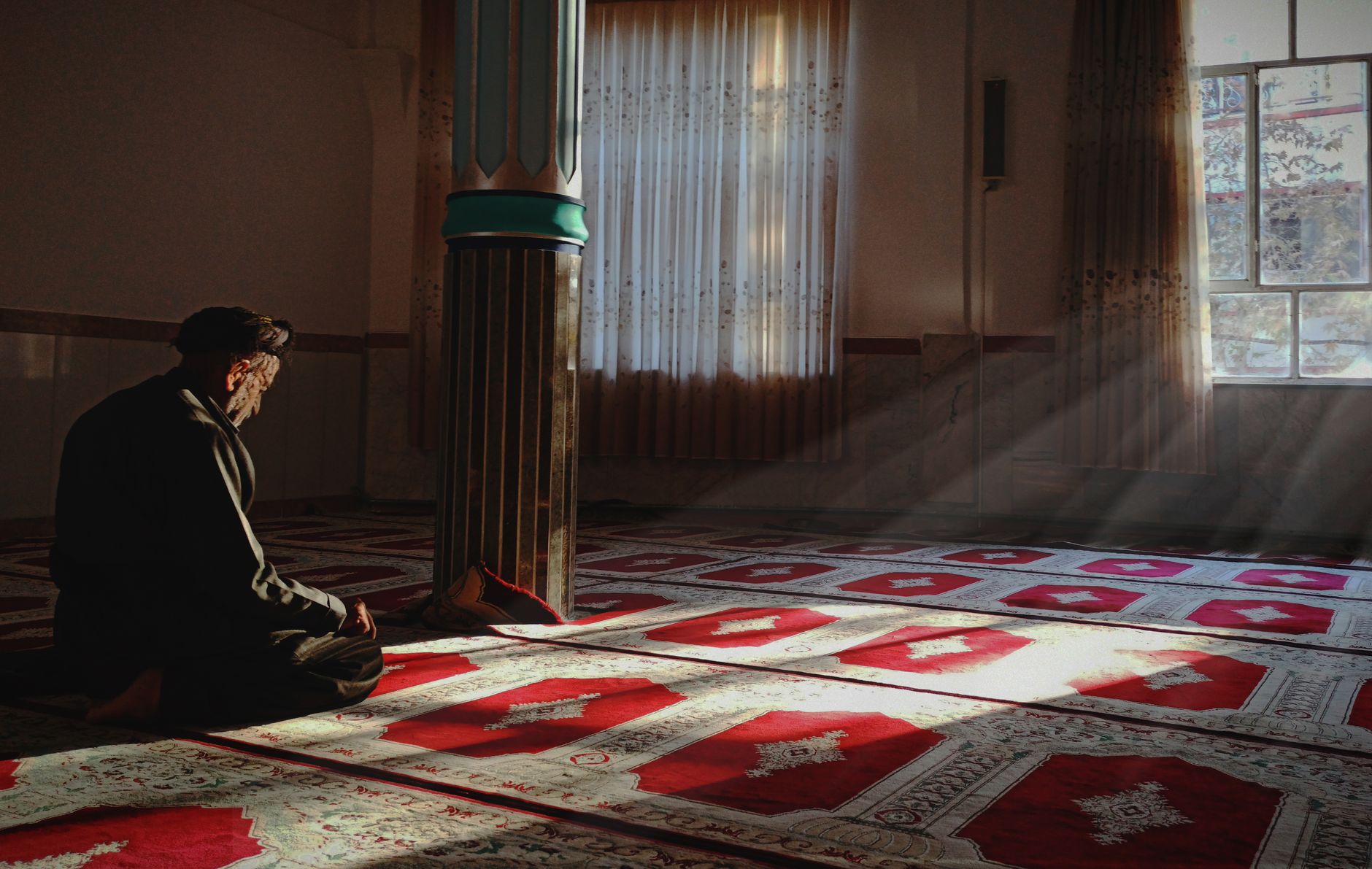 A person reading the Quran, reflecting on the teachings of Barzakh in Islam for spiritual guidance.