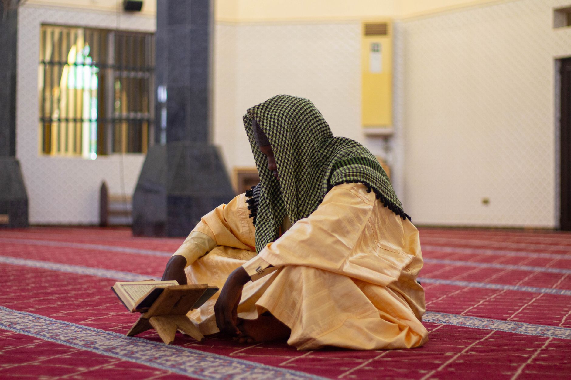 A person praying on a mat during the last ten nights of Ramadan in quiet reflection.