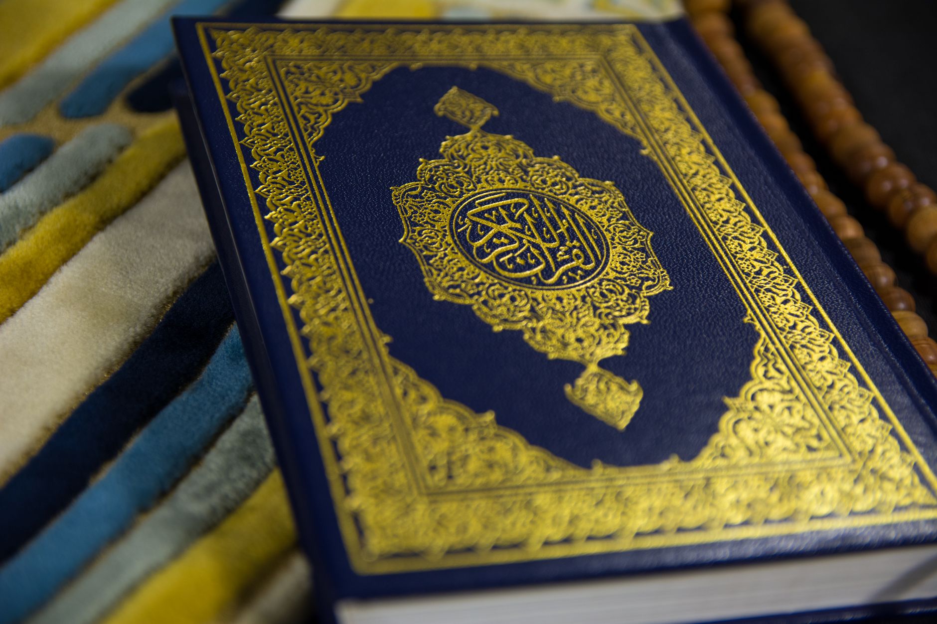 A person engaging in daily Quran reading by a window with soft morning light.
