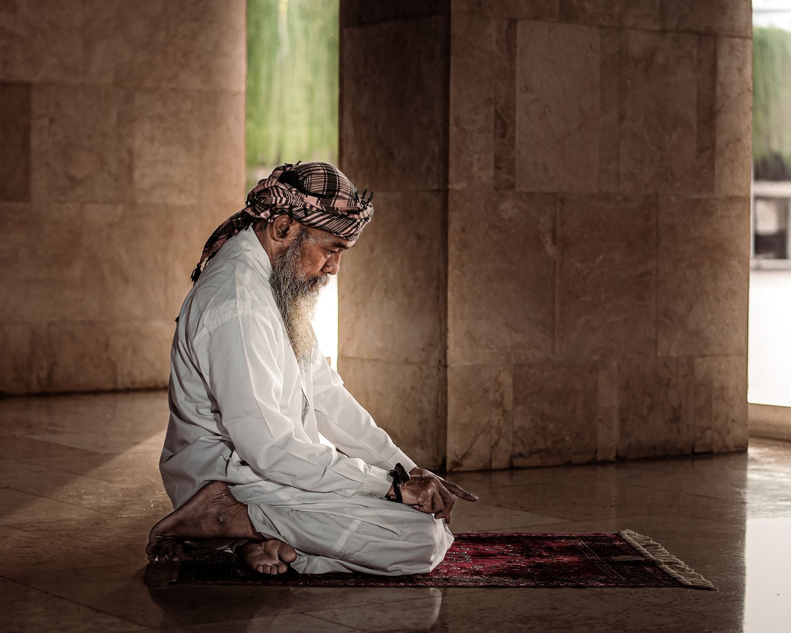 A wooden Quran stand with an open Quran, representing the study and reflection involved in Tahajjud prayer.